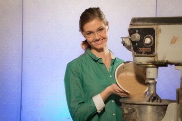 Sydney Dickson pours sand into a mixer in the civil engineering lab. Dickson is working on an honors thesis, which involves preventing damage to concrete by improving the ingredients that go into the mortar blend.